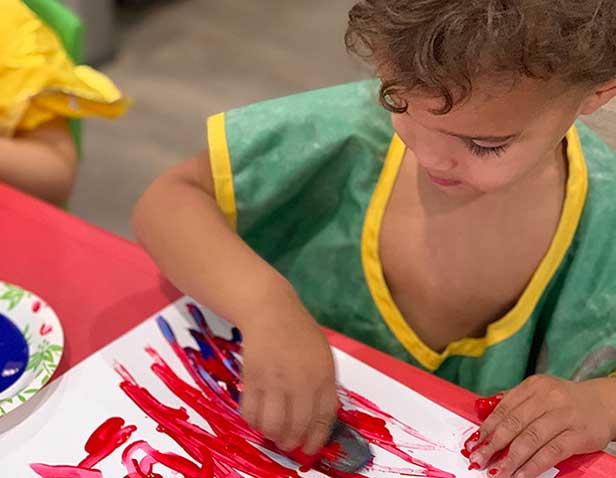 toddler at preschool doing arts and crafts in the toddler program